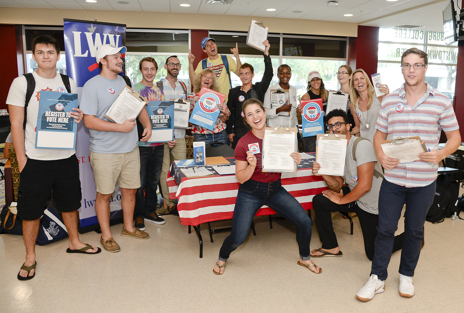 Group of people holding voter registration materials at a booth