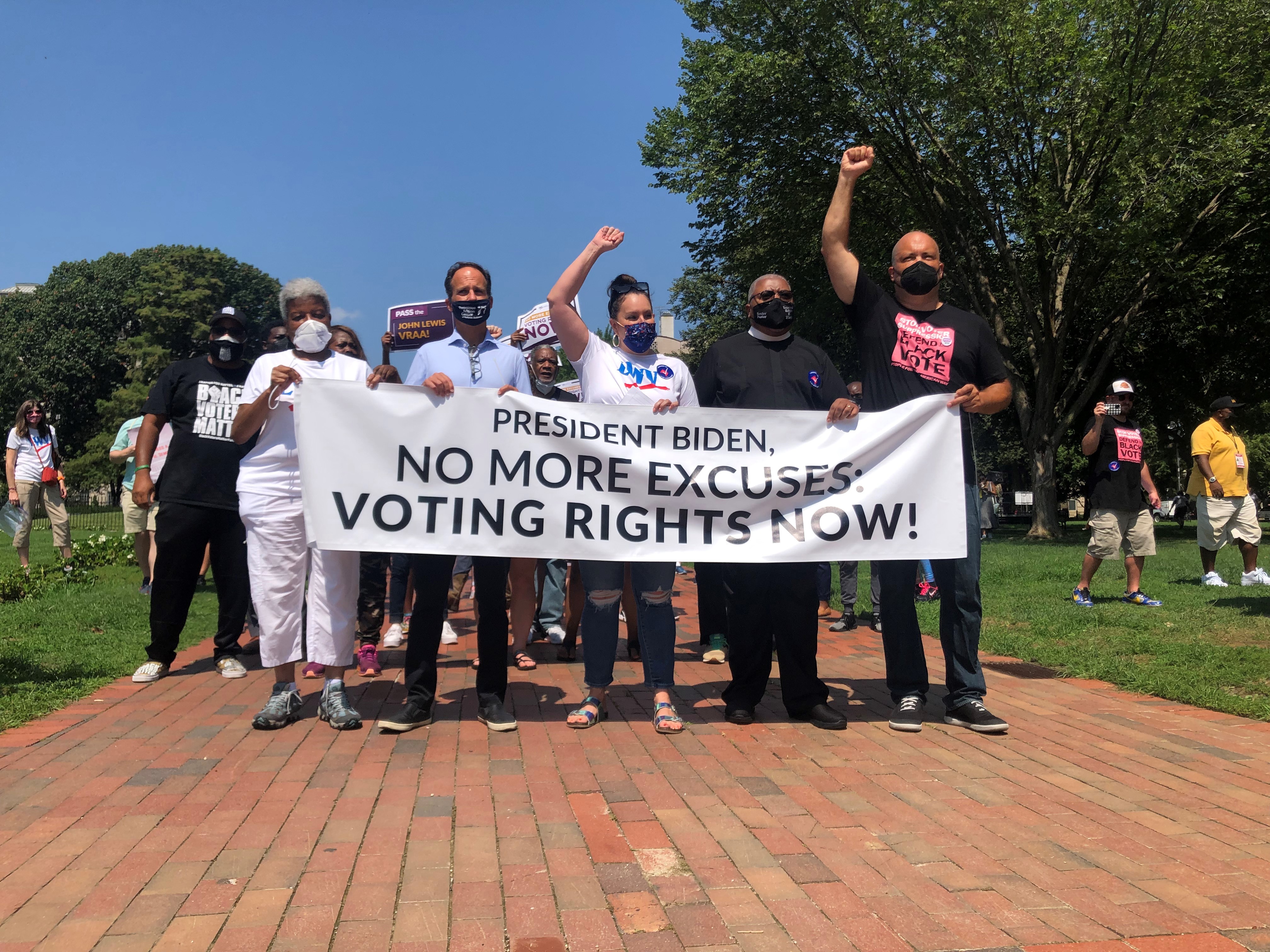 Photo of Dr. Deborah Ann Turner, Rabbi Pesner, Virginia Kase Soloman, Rev. McDonald, and Ben Jealous holding a banner that reads "President Biden, No more excuses: Voting Rights Now!"