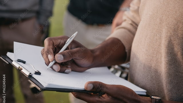 Person writing on a clipboard - Forms